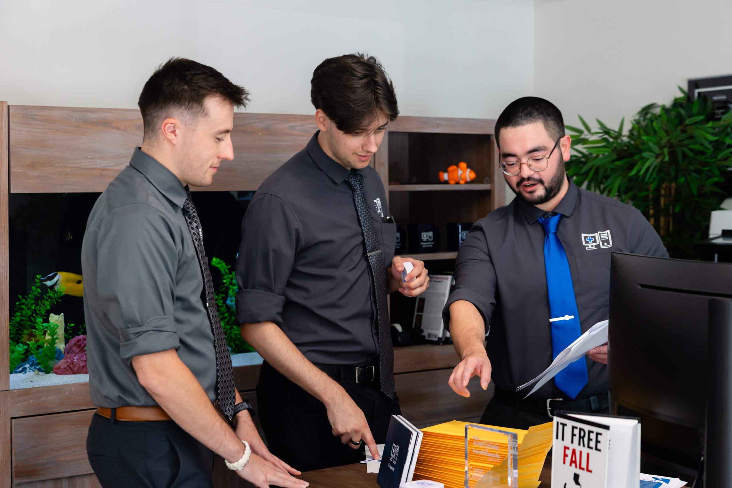 Three men gather around a table to discuss logistics. 