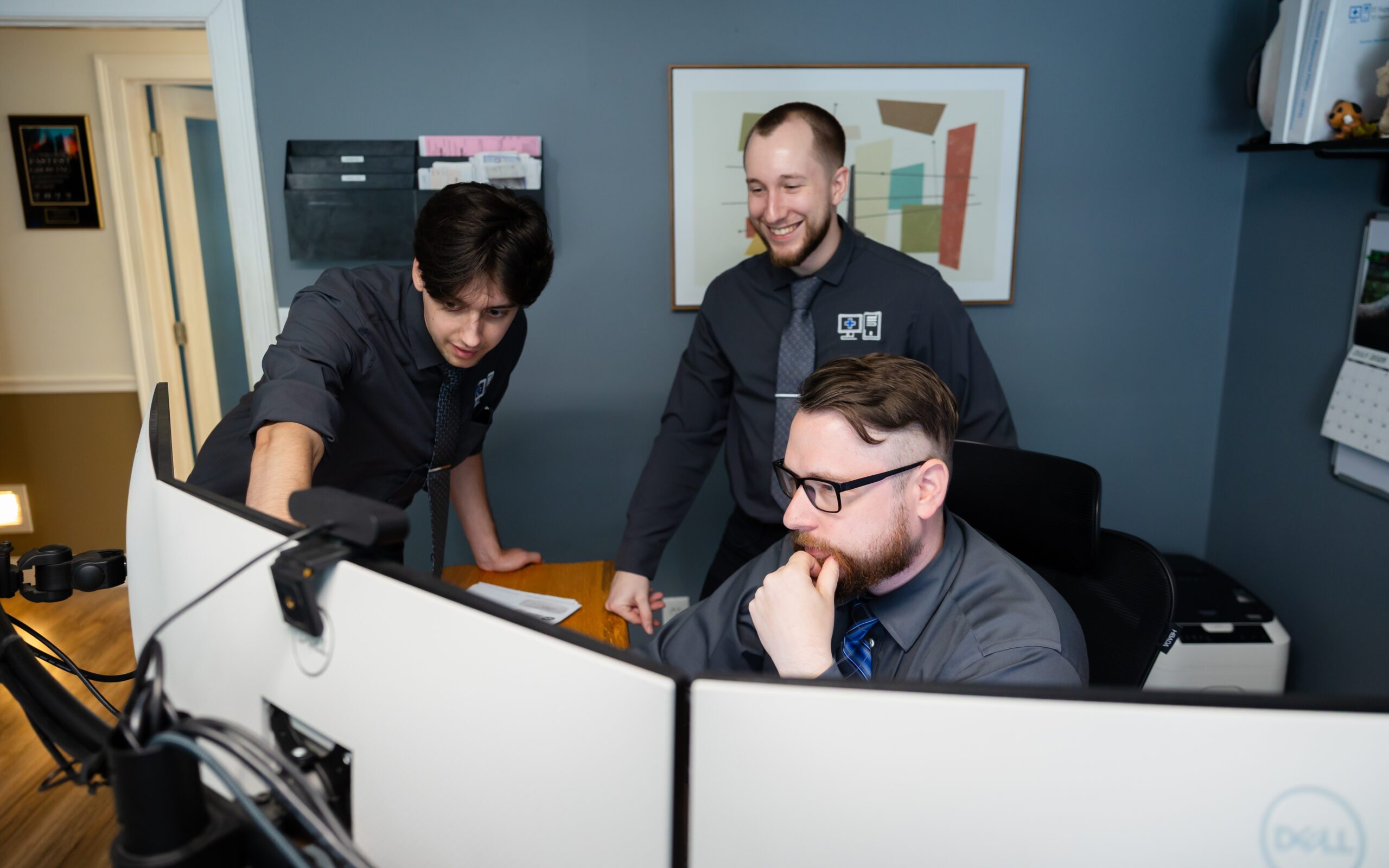 IT Support RI technicians discussing solutions around a monitor